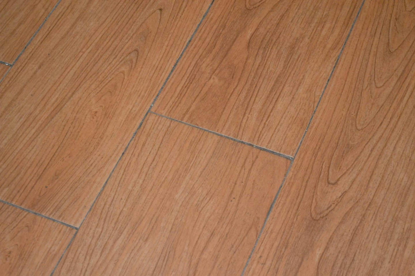 Pavimenti in assi di legno diagonali con motivi realistici di venature del legno.