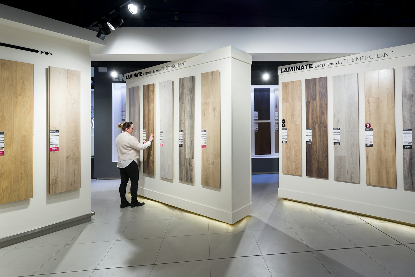 Donna sceglie campioni di laminato effetto legno in uno showroom.